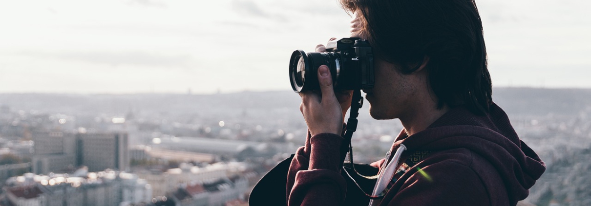 Freelancer Fotograf auf einem Berg fotografiert eine Großstadt
