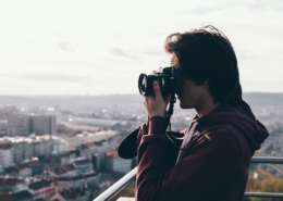 Freelancer Fotograf auf einem Berg fotografiert eine Großstadt