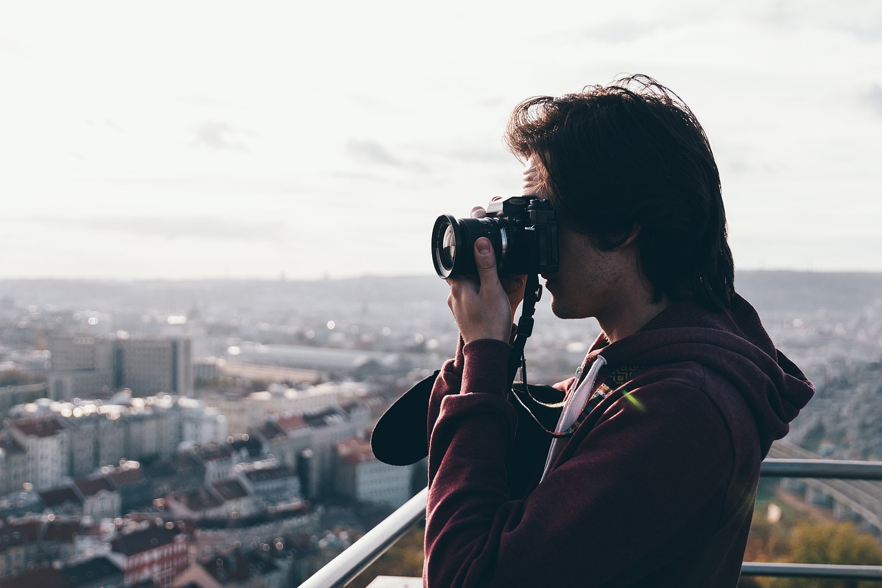Freelancer Fotograf auf einem Berg fotografiert eine Großstadt