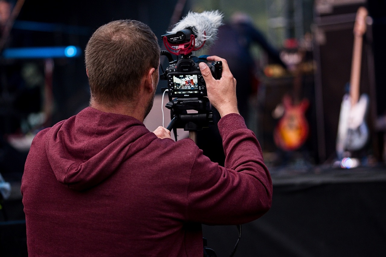 Freier Journalist filmt mit einer Kamera auf einem Konzert